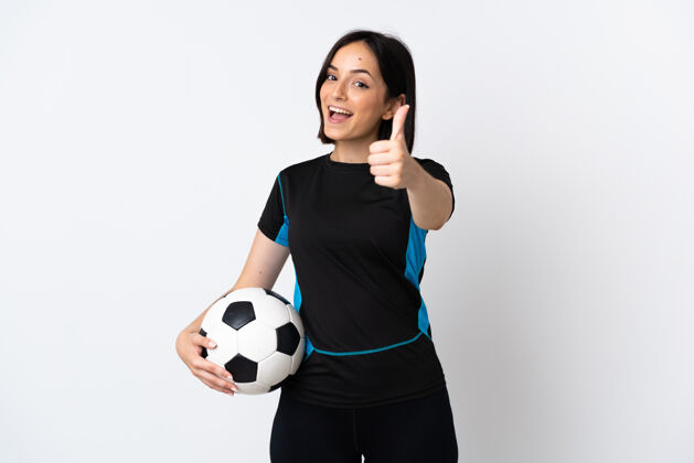 运动一个年轻的足球运动员 一个被隔离在白色背景下竖起大拇指的女人 因为发生了好事手指站立运动员