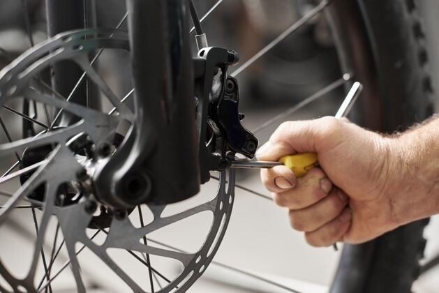 现代男技工在自行车修理厂用工具做服务自行车技能扳手