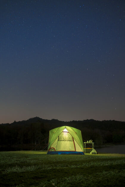 景观美丽的夜空与星星在帐篷营地 旅游和露营的概念令人惊叹的风景帐篷照明森林