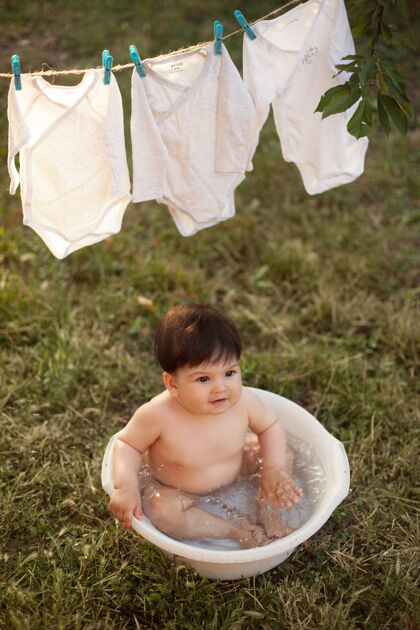 干日落时分 男婴在院子里的盆里洗澡身体院子湿