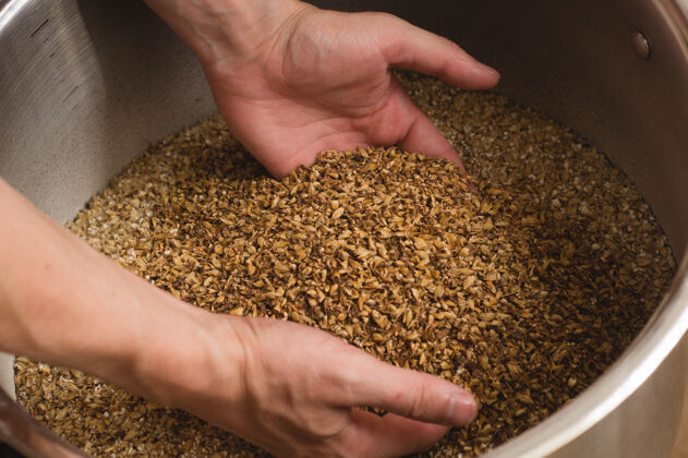 配料男性的手 从中倒入麦芽粉出去很好对工艺的态度自制深色谷物