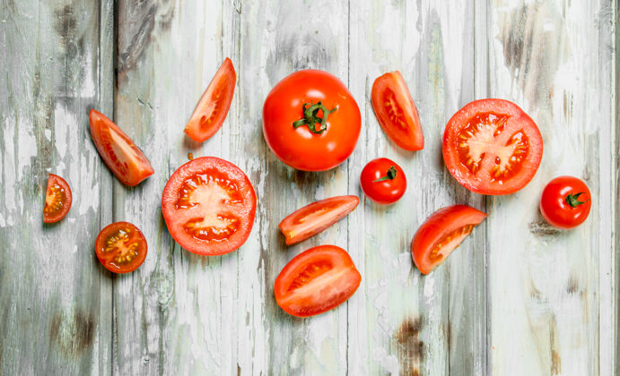切割白木桌上放着几片熟番茄吃抗氧化剂蔬菜