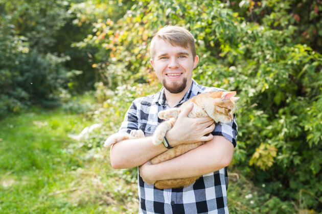 毛茸茸的帅哥带着可爱的猫在户外抱着生物可爱
