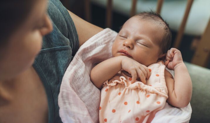 孩子刚出生的婴儿在安全地睡觉 而母亲抱着她微笑安全封闭温柔