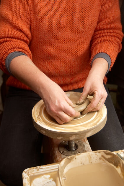 脏陶轮上陶罐的女性手Moldura形式湿