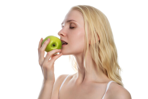 持有拿着新鲜青苹果吃白苹果的女人背景.节食健康概念生活方式白色年轻食物