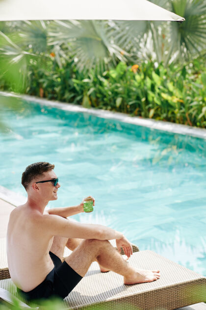 欢乐快乐的年轻人在阳光明媚的日子里 在游泳池边喝着冷鸡尾酒仅成人年轻人人