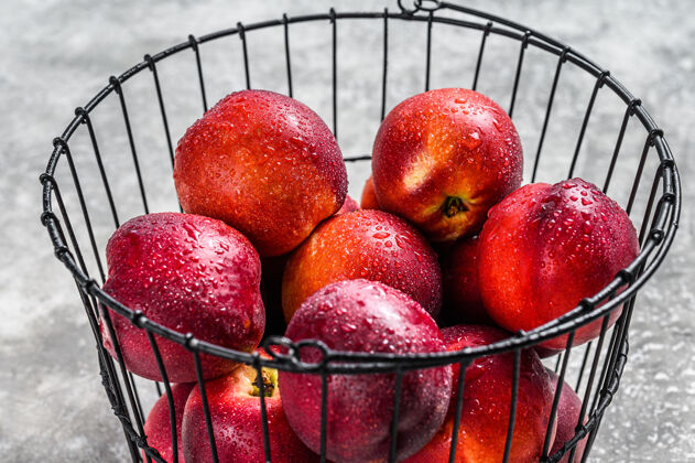 水果成熟的红油桃篮子灰色背景.top查看甜味油桃素食