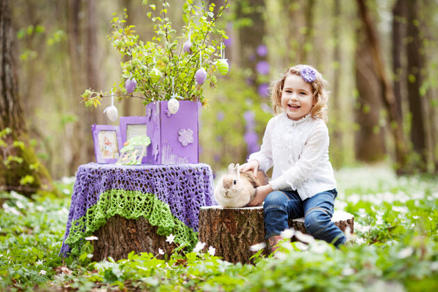 友谊小女孩在花园里玩真兔子花园大笑孩子和宠物在复活节彩蛋狩猎兔子春天带宠物的孩子们享受户外乐趣兔子孩子宝贝