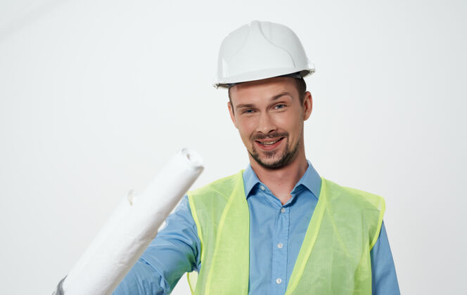 建筑师一个手里拿着一卷白纸安全帽的建筑工人工程师努力建筑