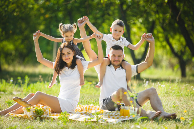 情绪快乐的家庭野餐父母在户外和孩子们一起吃晚饭节日爸爸玩