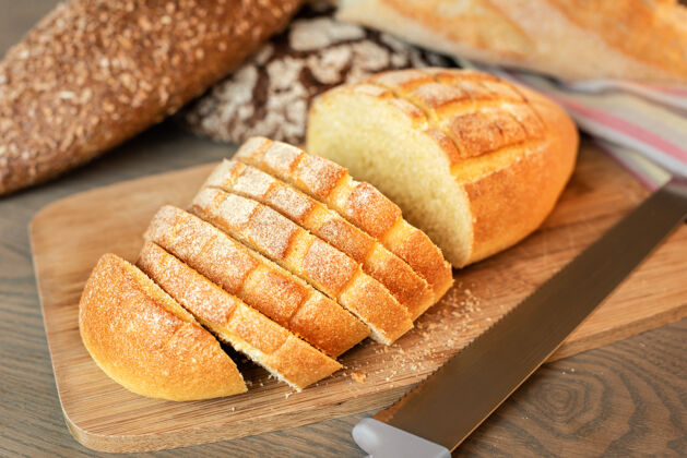 面包房桌子上的切片面包背景上有各种各样的面包健康不同吃