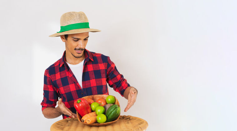 蔬菜一个戴着帽子和手套的黑人农民手里拿着一篮子蔬菜（胡萝卜 柠檬 西红柿 佛手瓜和甜菜） 背景是白色的携带农场快乐