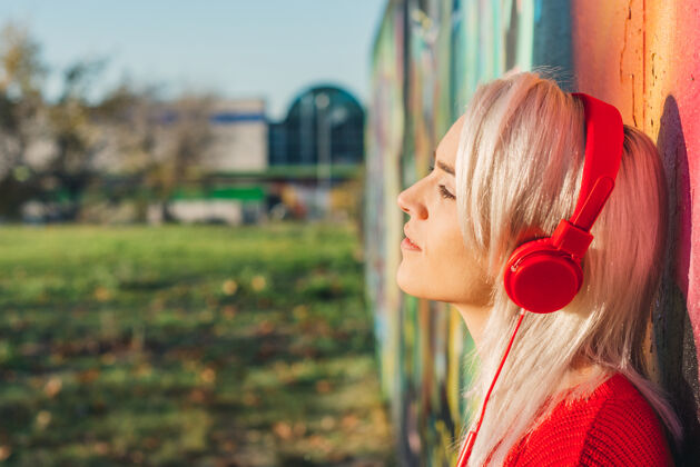 白金银发女孩红发听音乐耳机.倾斜涂鸦穿墙穿一件红毛衣休闲纯粹风格