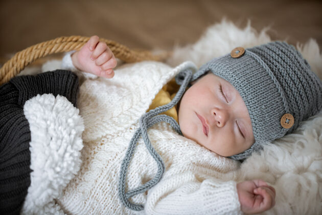 玩具一个睡着的婴儿的肖像 戴着一顶温暖的针织帽子 把手上放着一个针织玩具孩子毯子童年