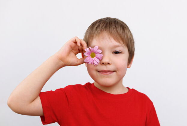 开花一个可爱男孩的画像 眼睛上戴着一朵花植物喜悦洋甘菊