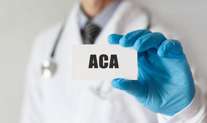 医学医生手里拿着一张有文字aca的卡片疾病改革法律