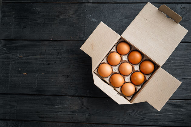 生的鸡蛋盒装鸡蛋盘 放在黑木桌上存储产品划船