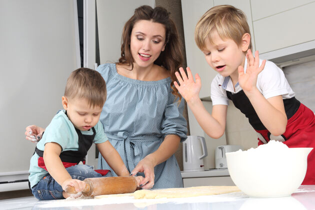 儿子妈妈帮小儿子在餐桌上揉面团教学烹饪团队合作