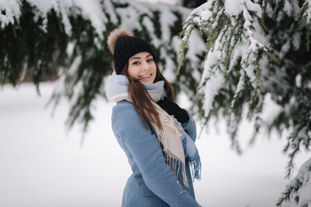 雪橇冬天的雪天 穿着蓝色外套的漂亮女人在树林里散步一起拉运动