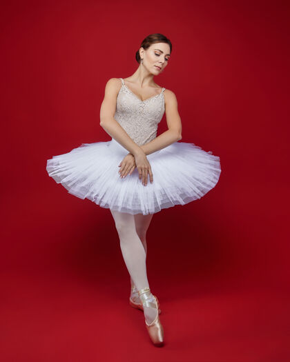 优雅迷人的芭蕾舞演员在红色背景上优雅地摆出姿势运动平衡衣服