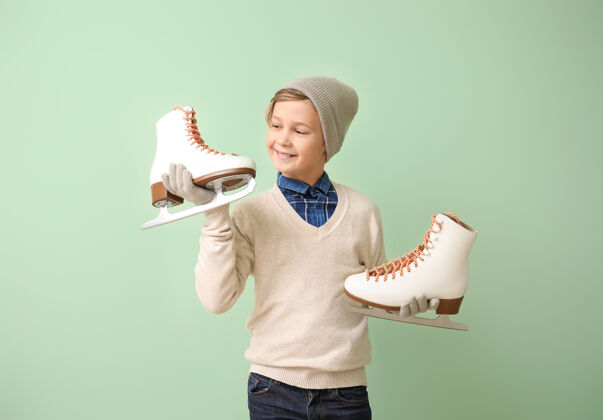 刀片可爱的小男孩和彩色的溜冰鞋温暖孩子男孩