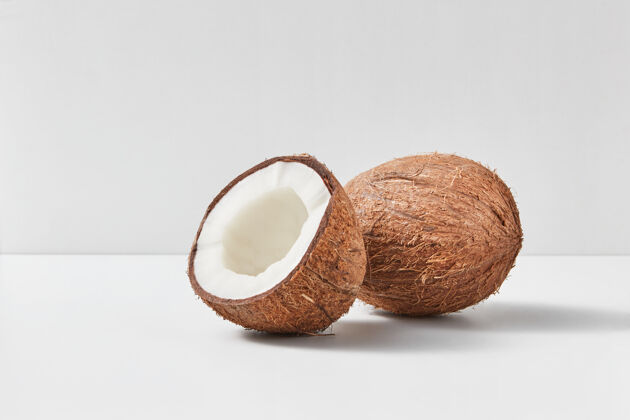 配料全天然的异国风味成熟椰子果 一半放在双色浅灰色背景上 柔和的阴影 复制太空素食者概念椰子油半