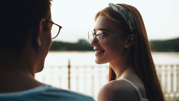 抱着一对戴眼镜的高加索夫妇坐在桥上 以湖水为背景互相对视姜拥抱冒险
