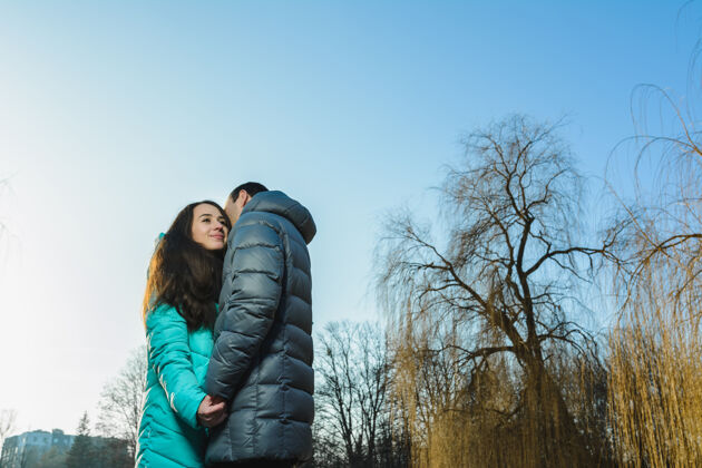 年轻情人节快乐的小情侣在冬季公园玩得开心城市在一起木头