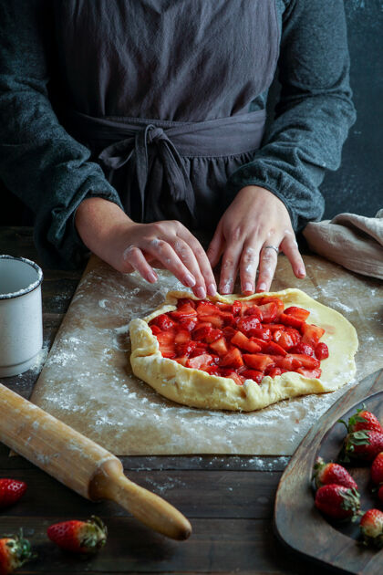 草莓加莱特用新鲜草莓制作的过程中 年轻女子双手 用面团工作顶视图馅饼加莱特