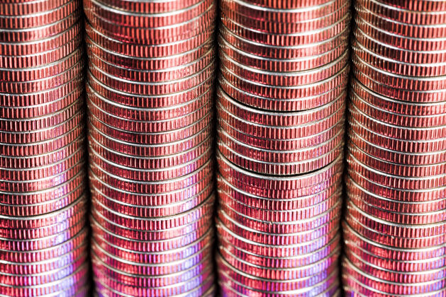 增长许多银色的圆形金属硬币用红色照亮支付变化设置