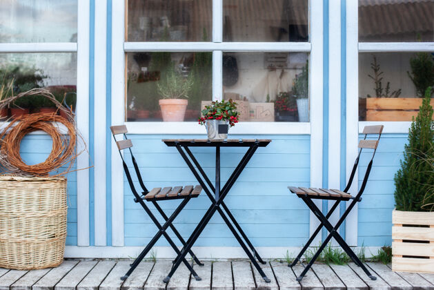 庭院阳台上有柳条筐和绿色的花盆植物家木头阳台上的桌椅室外住宅家居装饰小屋室外椅子