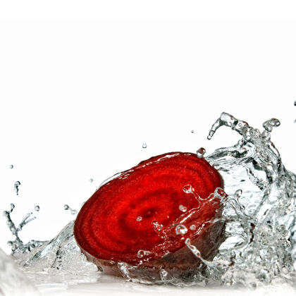 运动红甜菜与水飞溅隔离在白色下降吃飞溅