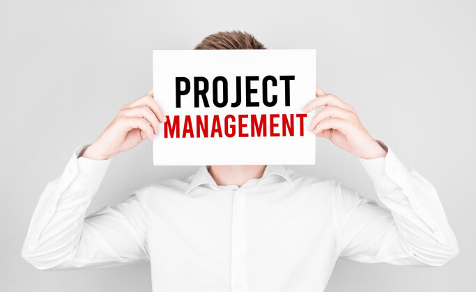工作流男人用白纸遮住脸 上面写着项目管理的文字领导经理资源