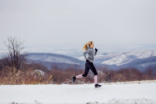 活跃在雪地上奔跑的女运动员冬天健活方式 冬季健身 寒冷天气寒冷女性健康的生活方式