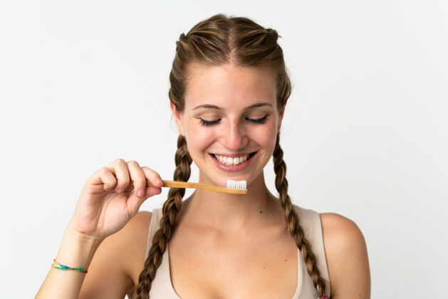 牙科一个年轻的白人妇女用牙刷把自己隔离在白色的地板上刷子墙壁早晨