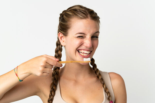 人一个年轻的白人妇女用牙刷把自己隔离在白色的地板上卫生年轻护理