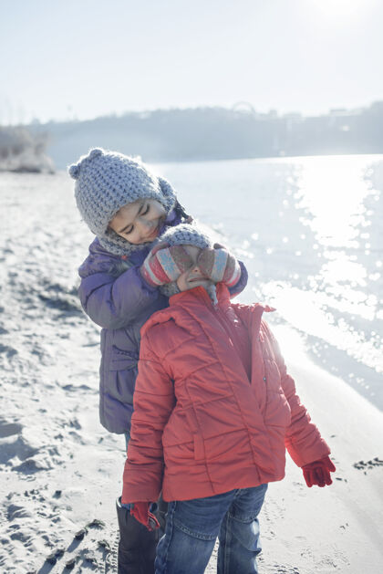 家人一家人一起过冬 孩子们冬天在沙滩上散步哥哥编织帽子兄弟姐妹