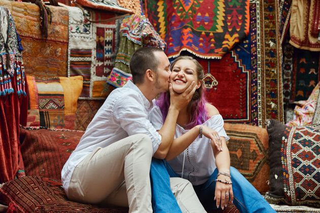 蜜月相爱的情侣在市场上挑选土耳其地毯地毯商店亚洲
