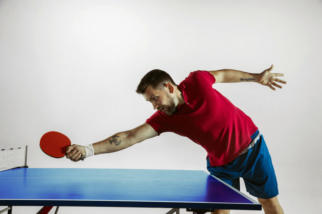 动作在白色工作室墙上打乒乓球的年轻人白种人运动活动