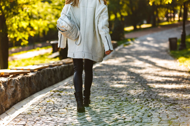 吸引力一个穿着秋衣 戴着秋帽的年轻女子在城市街道上走在户外的后视图城市优雅女孩