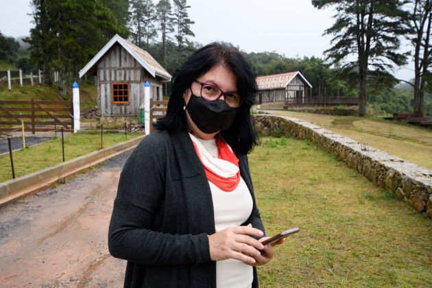 山在大雾天戴着口罩 手持电话的农村妇女雾女人秋天