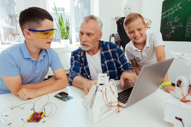 学习学校教育一个和蔼可亲的人一边看着他的学生 一边向他讲解现代技术智慧设备老年