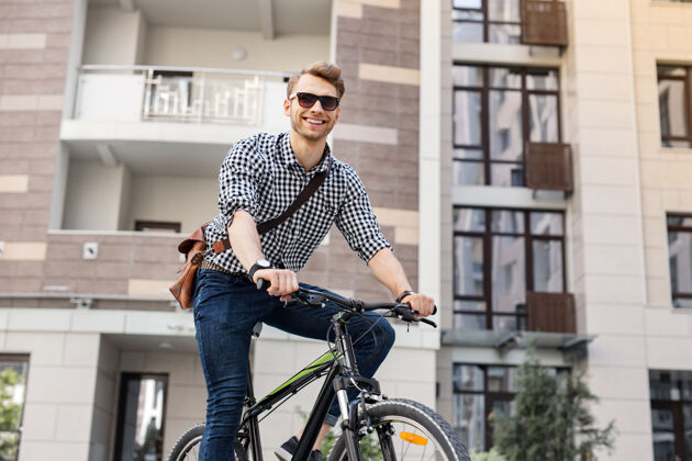 消遣体育活动快乐的好人骑自行车保持健康自行车年轻男性
