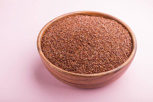 美食木碗与生的红色奎奴亚藜种子粉彩表面营养厨房生的