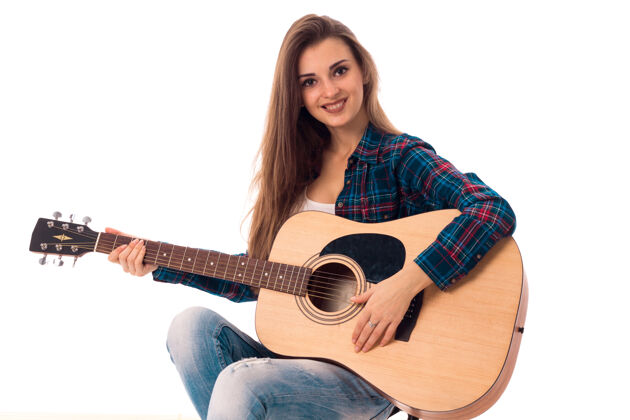 表演在白色的墙上 快乐的女人手拿吉他微笑的肖像女性吉他手衬衫