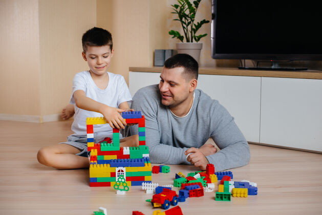 颜色一个小男孩和他的父亲一起被一个建造师扮演 建造了一座房子建造了一个家庭的家游戏建造童年