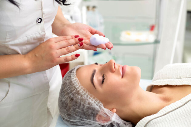 恢复活力用泡沫清洁皮肤 美女在美容院美容美容师工作女性皮肤护理水疗