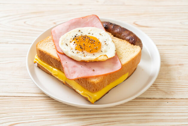 蛋早餐自制面包烤芝士火腿炒鸡蛋配猪肉香肠早餐法国小吃