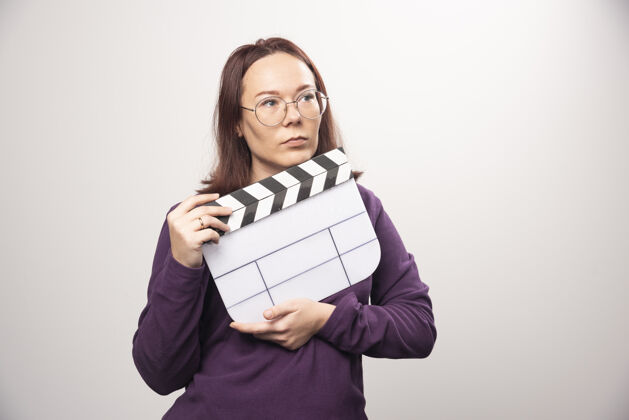女性一个年轻的女人在一张白色的照片上摆着一个电影院的带子高质量的照片女人年轻人磁带